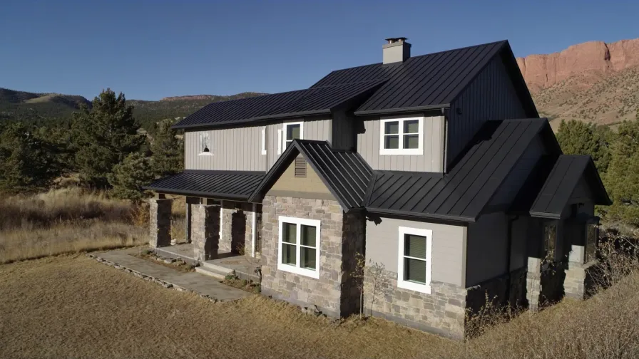 Two-story house with a dark standing seam metal roof in the Colorado Front Range foothills